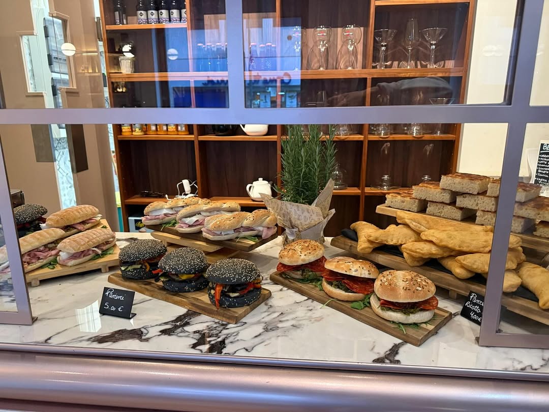 Panini con pane nero e focacce farcite nella vetrina